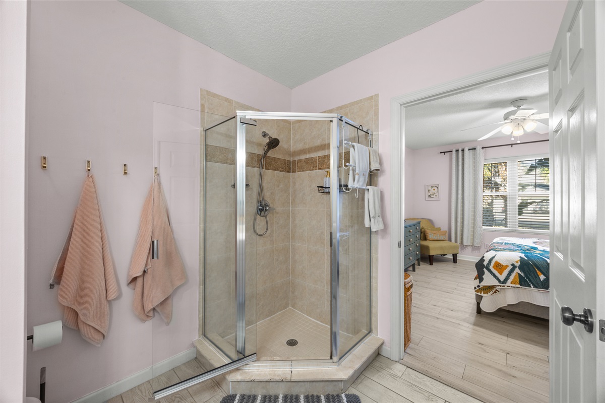 Bright and chic entry way into primary ensuite bathroom with glass shower and modern touches.