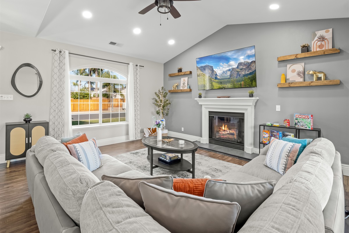 Cozy gathering space with a warm fireplace, large smart TV, and oversized sectional—plus board games for fun family nights in.