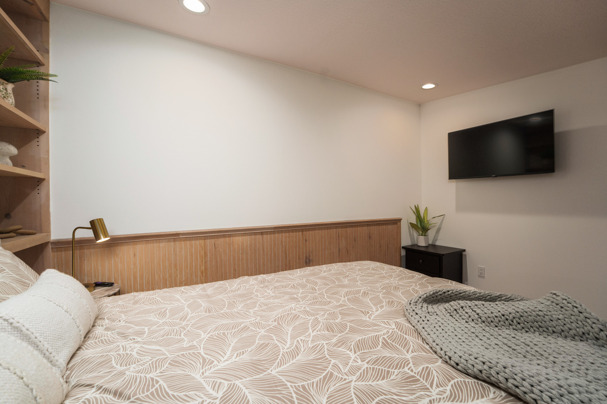 Bedroom 3 offers a comfortable queen bed for two, built-in shelving, and direct access to Bathroom 3, which is shared with Bedroom 4.
