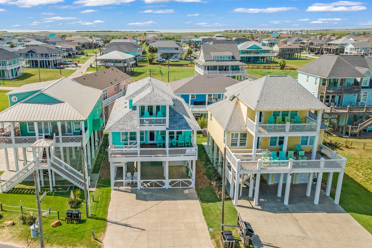 Sandy Toes: From the air: Our turquoise beach house with balconies and a prime beachside location.