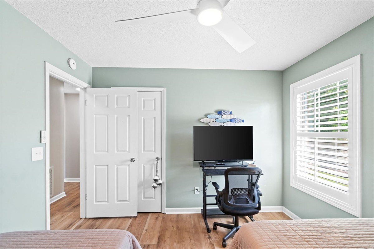 Third bedroom with two beds and workspace