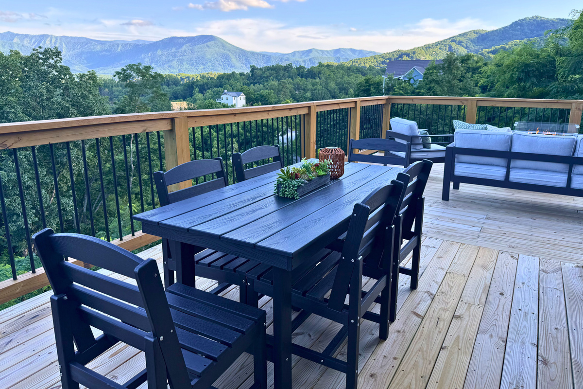One of two matching dining tables on the upper deck — outdoor seating for 12 with the Smokies all around.