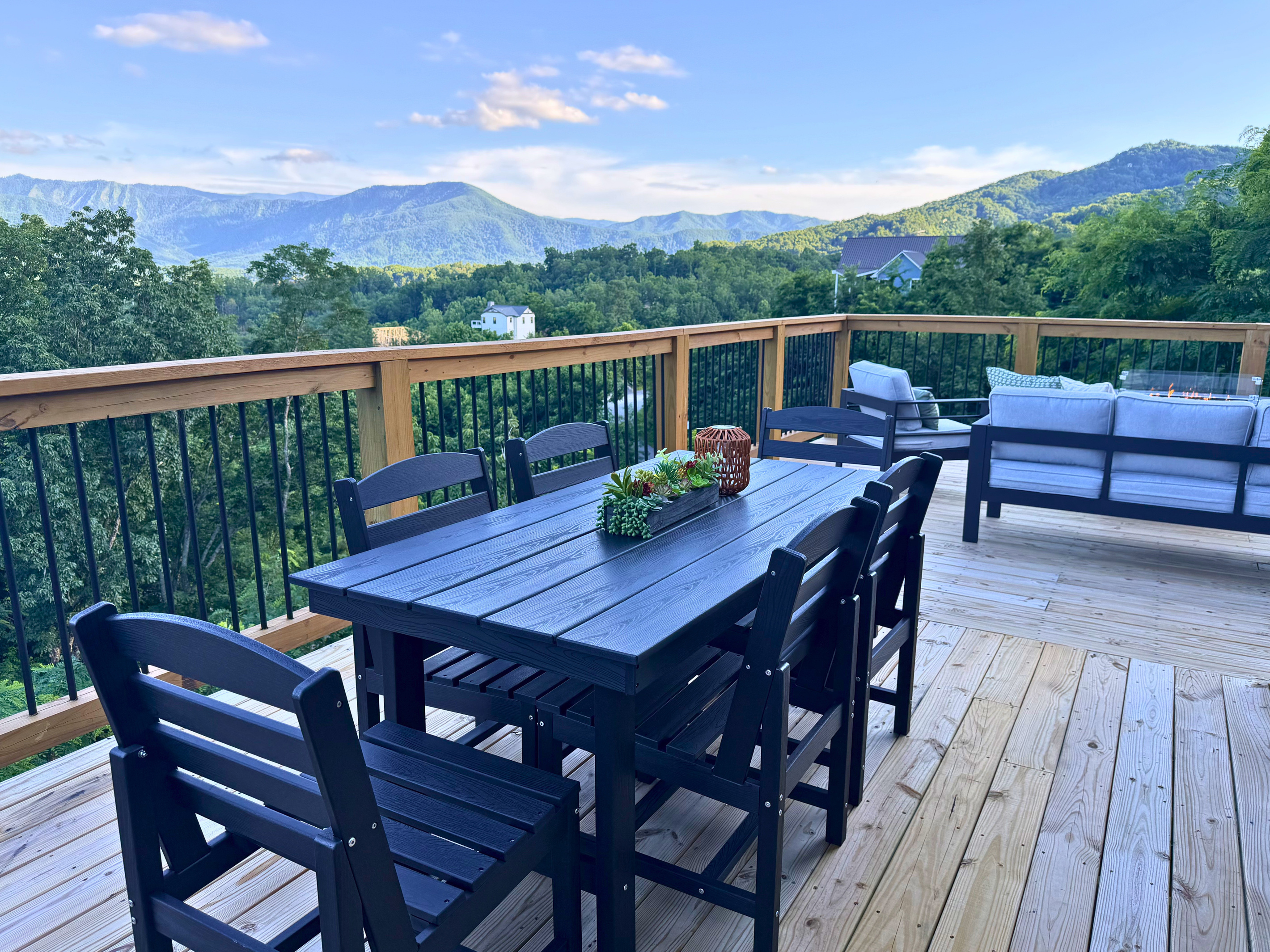 One of two matching dining tables on the upper deck — outdoor seating for 12 with the Smokies all around.