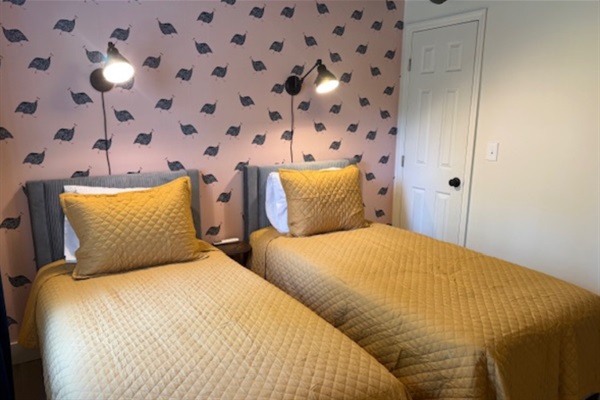 Bright and playful second bedroom with funky wallpaper, twin beds, and a fun, cozy vibe for your stay near University of Georgia.