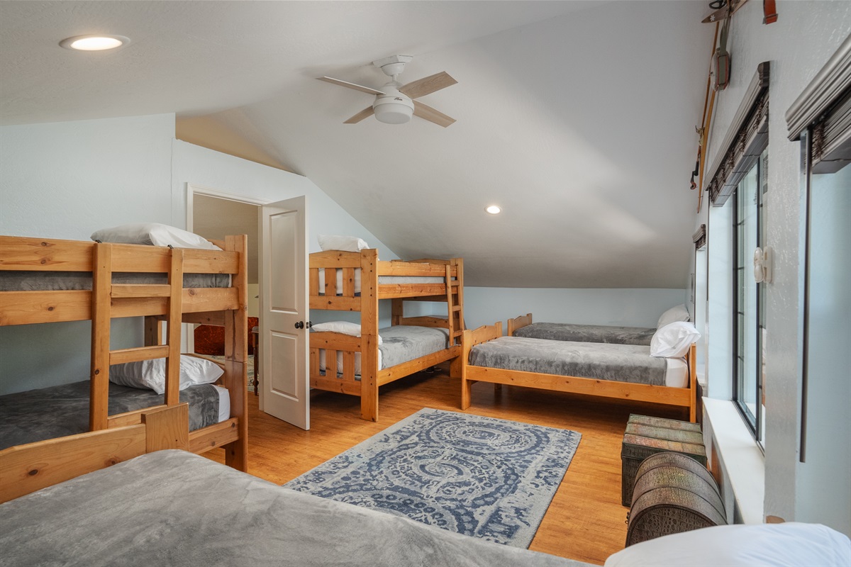 A fun and spacious kids' bunk room featuring two twin bunks and four single twin beds. Perfect for  group gatherings.