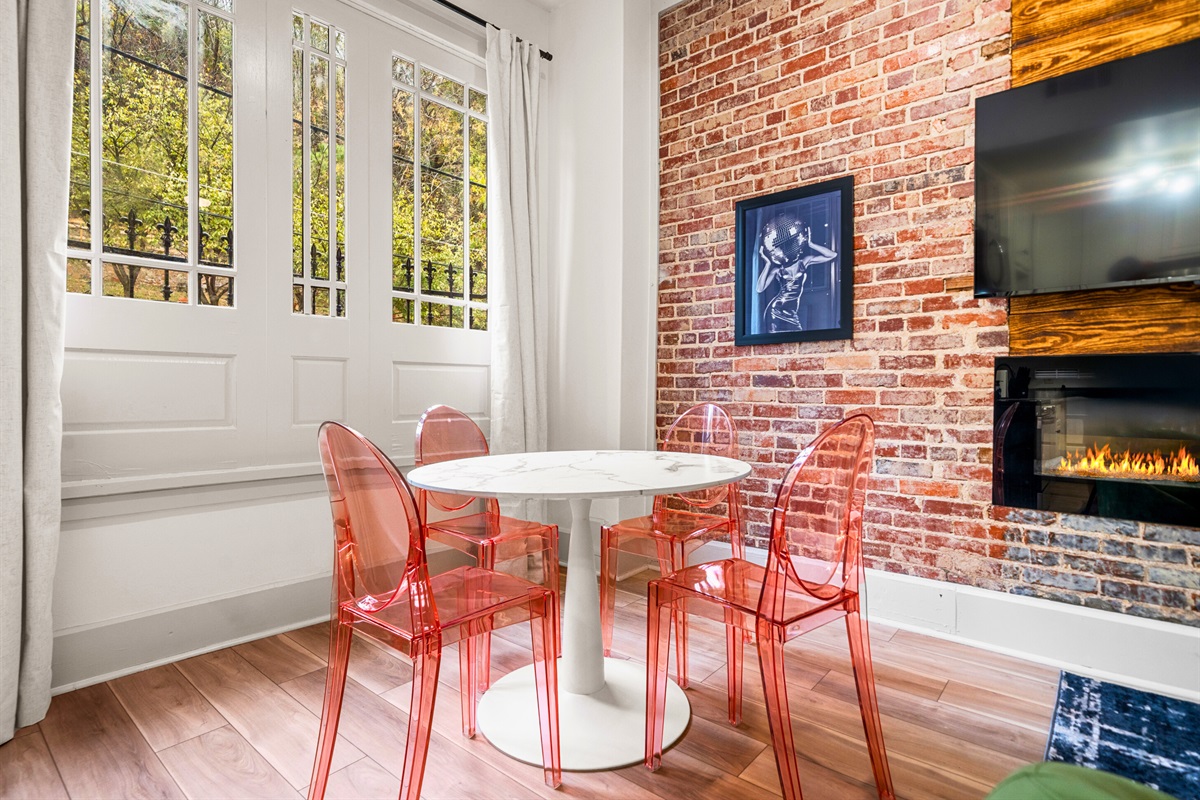 A chic dining nook with clear chairs and natural light provides the perfect spot to enjoy your meals or a cup of coffee while soaking in the downtown vibes.