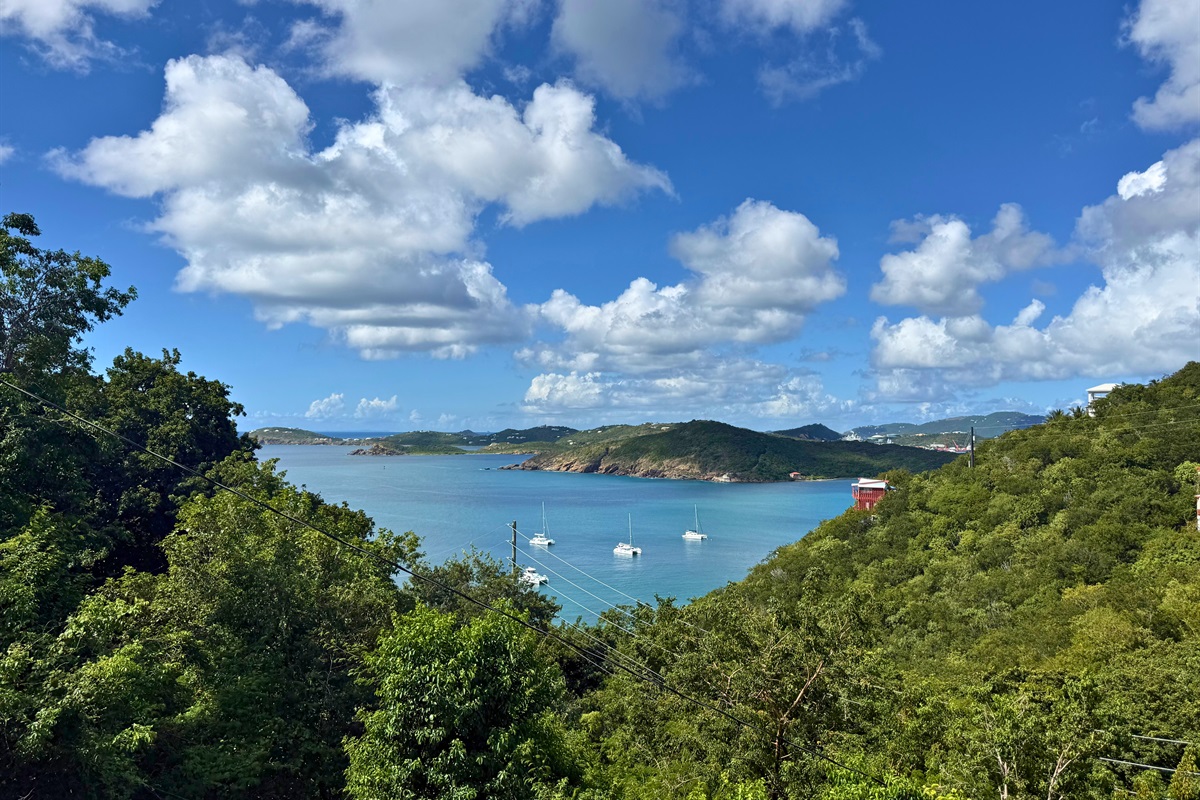 The green mountains surround the bright blue Caribbean water