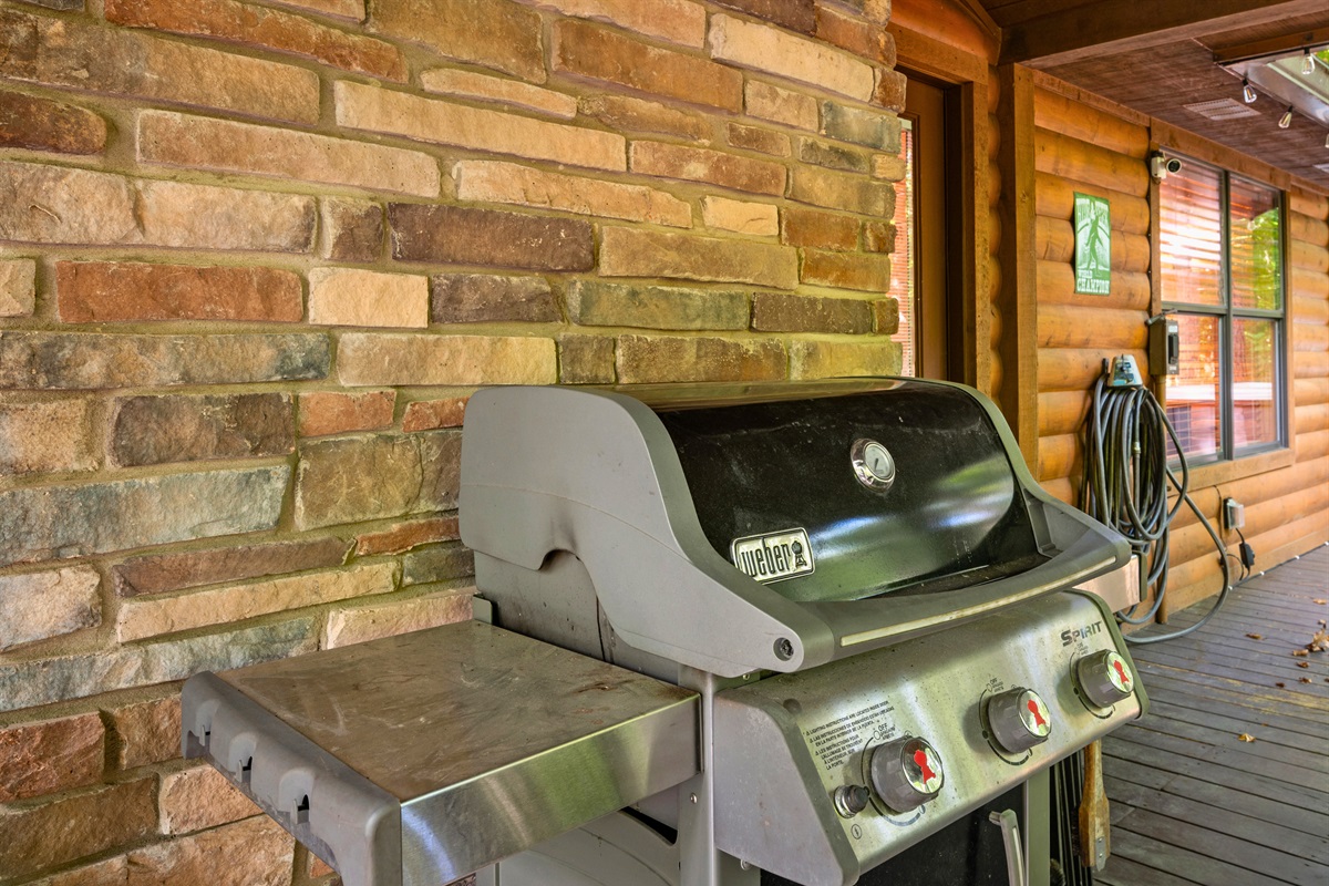 Outdoor gas grill ready for backyard barbecues or cabin cookouts under the trees.