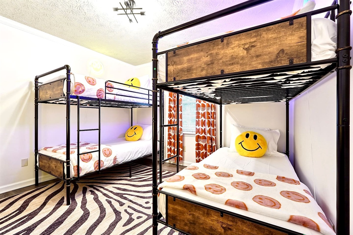 Bedroom 5 is located upstairs, features double bunk beds and a TV. This room does not have a private en-suite bathroom but has access to a shared bathroom.
