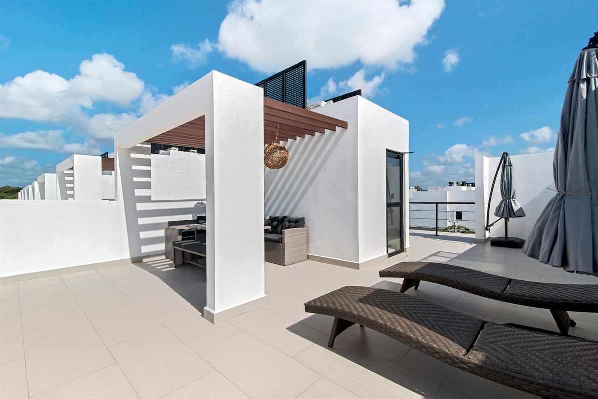 Seating area and 2 longer chairs facing all courts and pools 