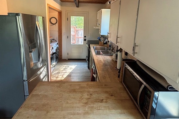 Kitchen, with washer dryer back left.  Door to small back deck and yard.