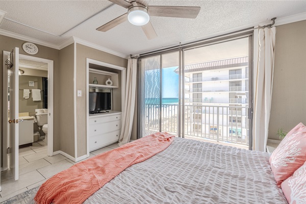 Master bedroom #2 with ensuite bath, ceiling fan, smart TV, and balcony access