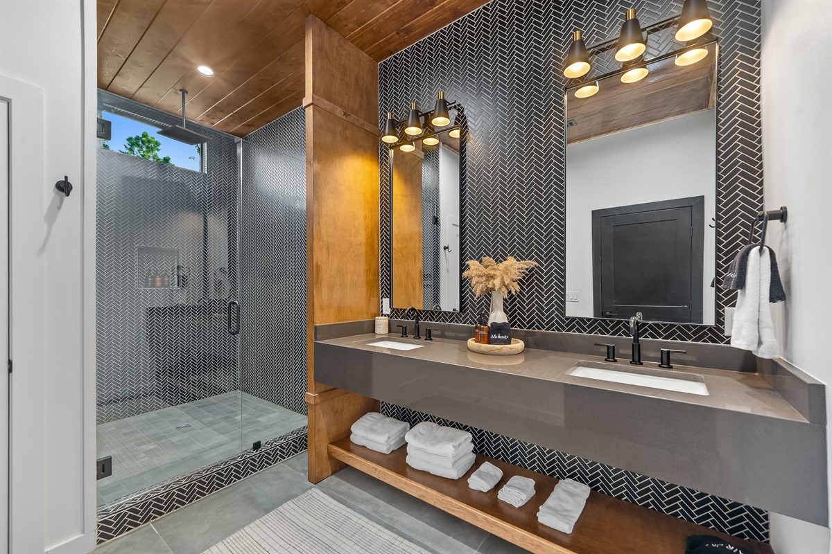 Semi-private bathroom for those staying in the Bunk room. This bathroom features modern teak finishes, stunning modern design, and an oversized rain shower with dual shower heads. 