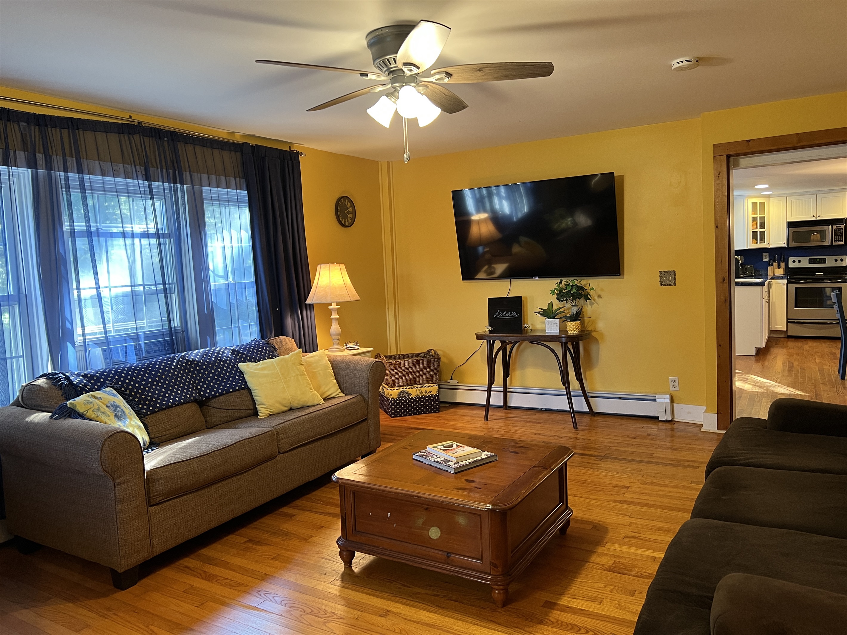 Dandelion main living room with 65" smart TV and view into the kitchen on the right.