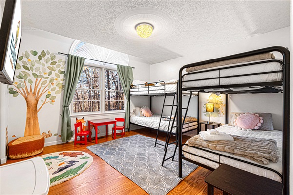 The bunk room is a haven for kids with 4 cozy bunk beds and a selection of toys to keep them entertained for hours. The playful decor and fun bedding create a whimsical atmosphere that kids wi