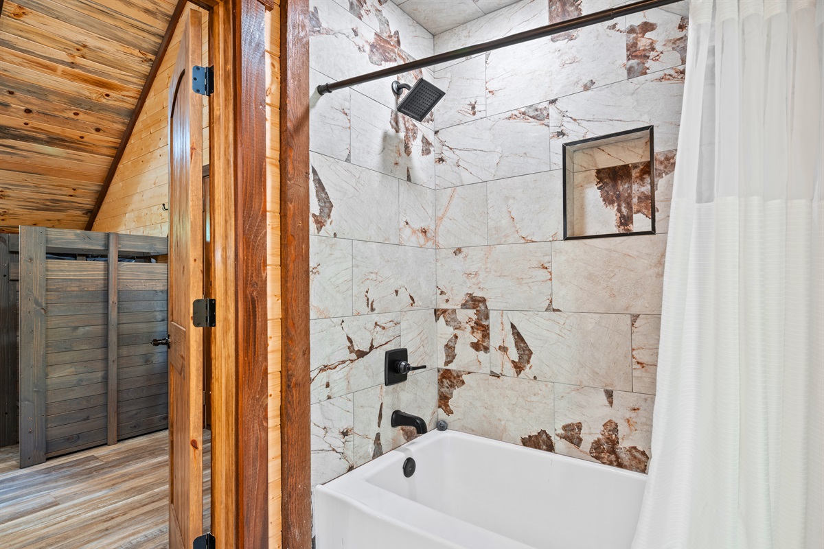Spacious walk-in shower with stone details.