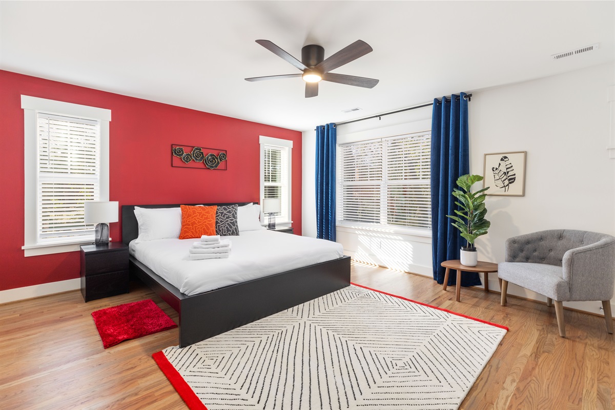 The spacious primary bedroom upstairs has a King bed, luxurious linens, and a TV for watching shows in bed.