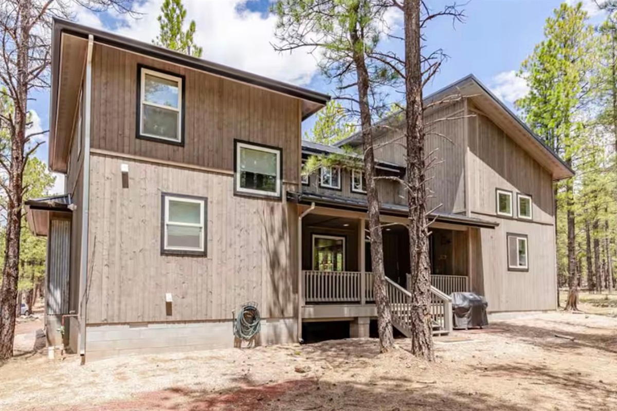 Exterior view of the cabin nestled among tall ponderosa pines.