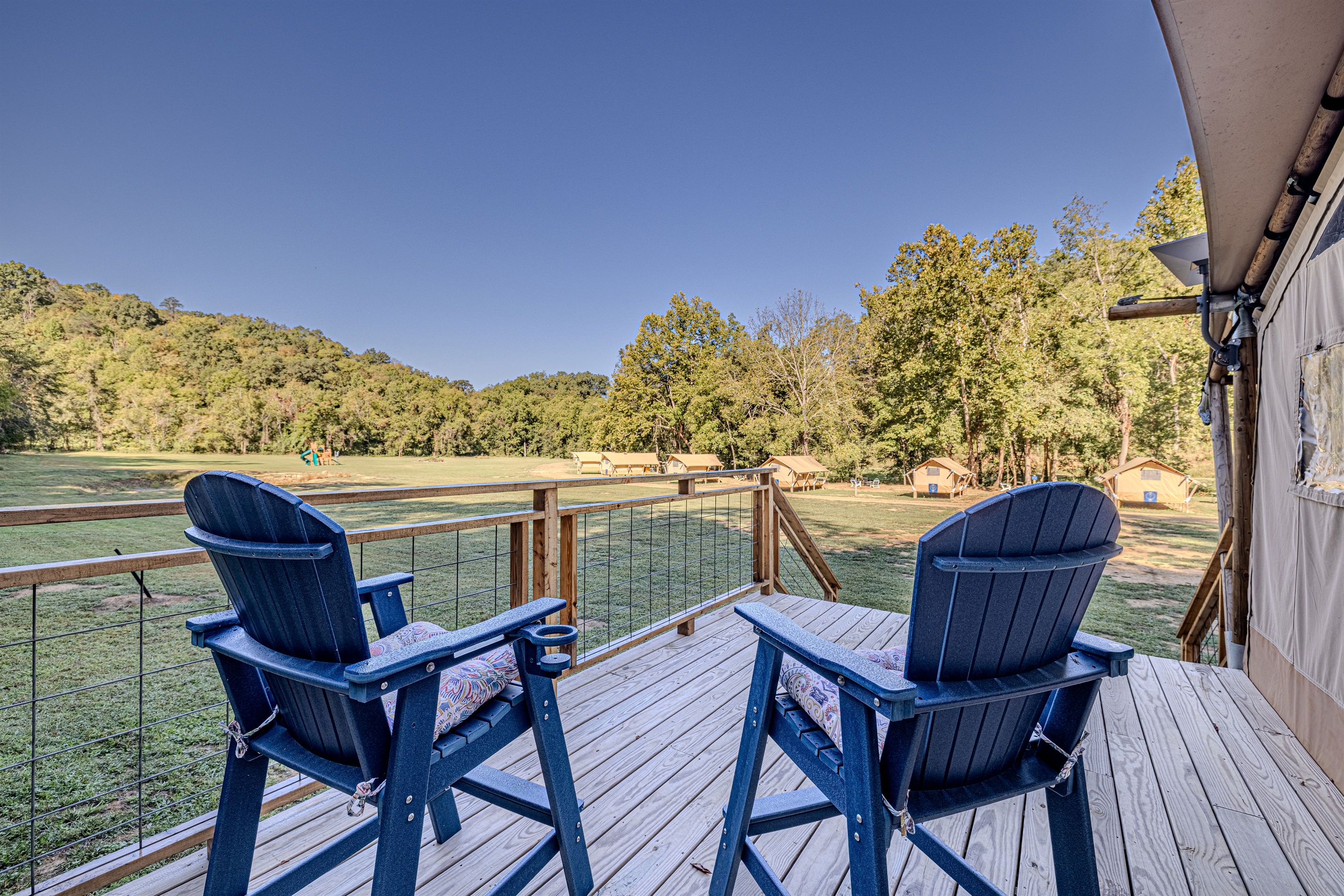A moment of peaceful observation. From this vantage point, you can enjoy the full view of the glamping grounds and the surrounding forest, offering a sense of openness and tranquility.