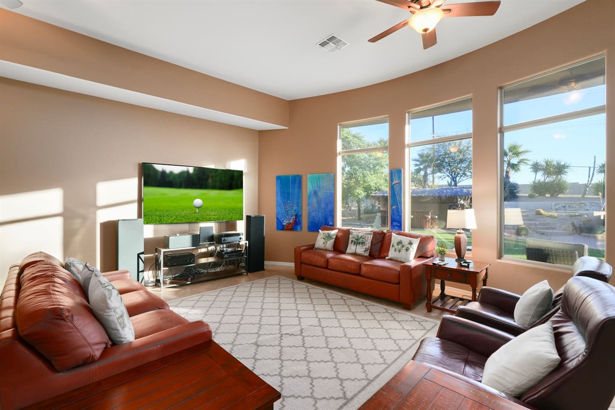 Spacious open-concept living room with Smart TV, leather seating, and natural desert light