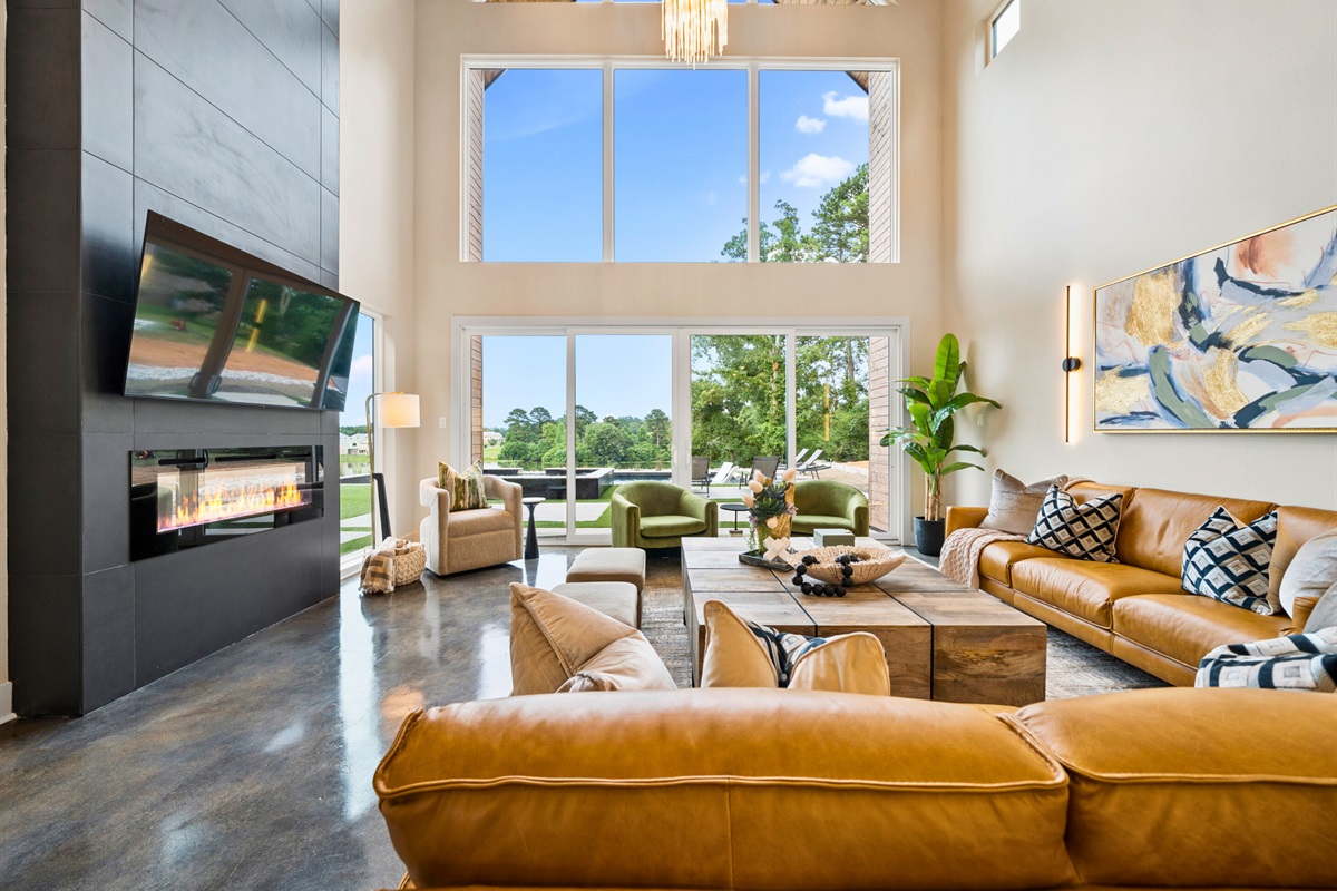 The living room offers breathtaking outdoor views through expansive windows that flood the space with natural light.