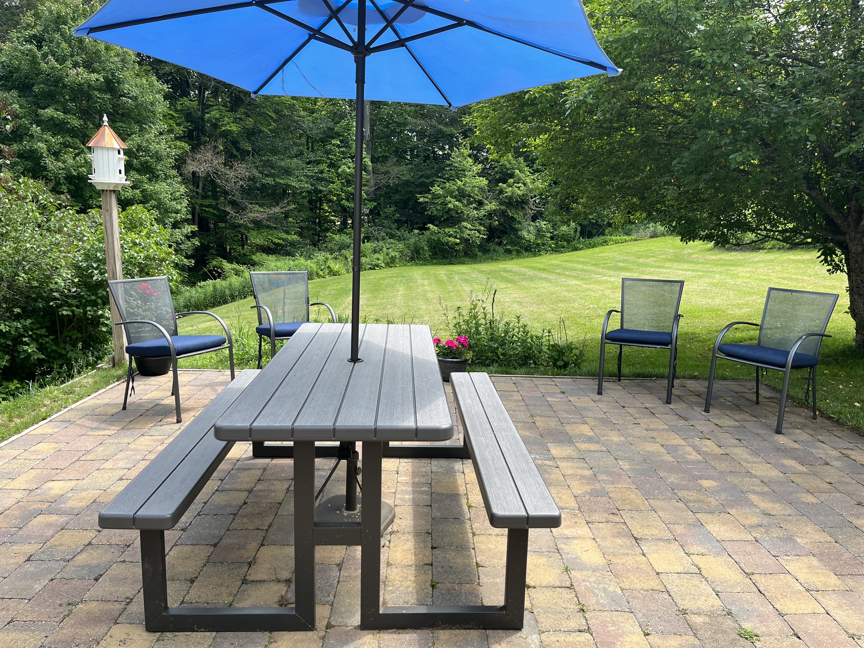 Side patio with chairs, table and charcoal grill