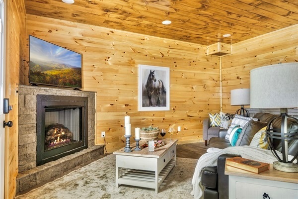 A luxurious living space featuring a spacious, comfortable couch, armchairs, and a 65-inch LED smart TV, surrounded by elegant decor."