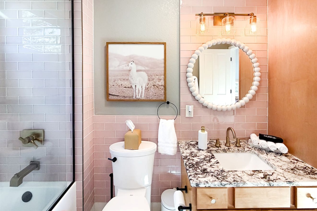 This custom-made bathroom is bright, cheerful, and inviting, featuring a tub, shower, fluffy towels, and gentle soaps. Thoughtful details make it both functional and charming for all ages.