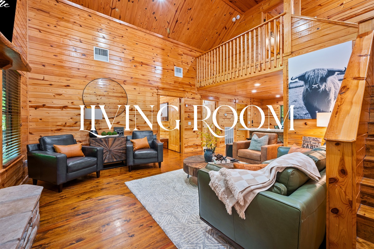 The living area has vaulted ceilings, leather seating, and cozy decor — perfect for lounging or games.