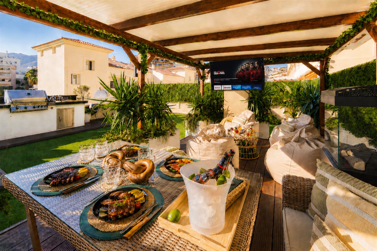 Relax beneath the covered pergola with cozy seating, fireplace, and dining area. Perfect for long evenings, romantic dinners, or movie nights on the outdoor TV under soft ambient lights.