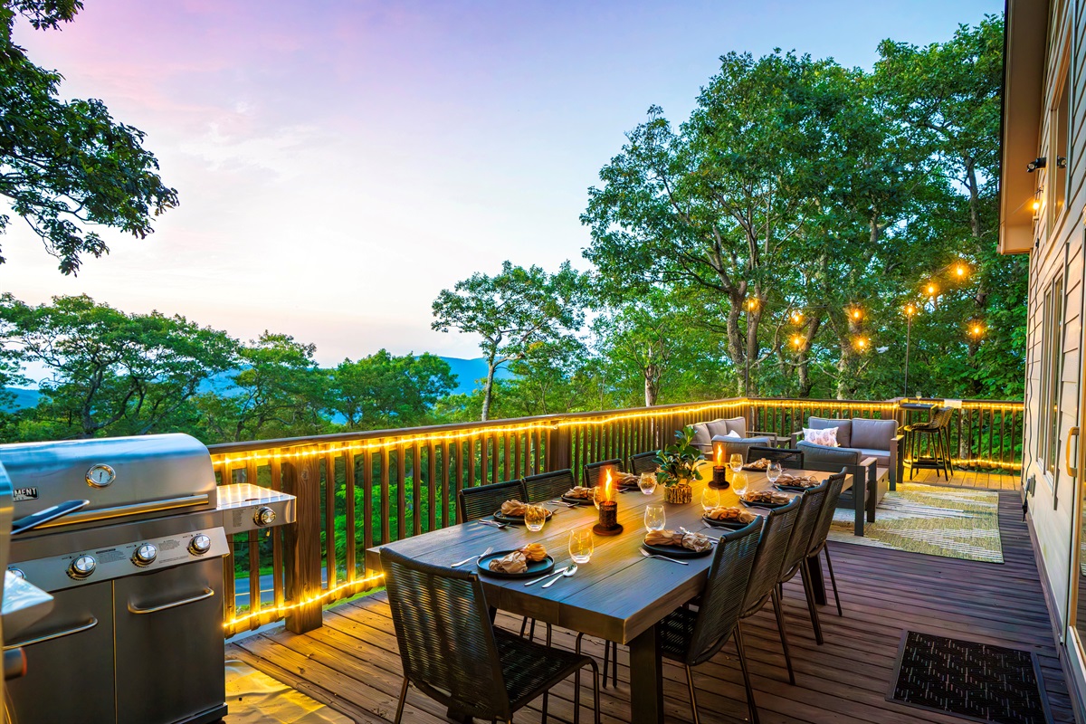 Twilight on the deck — mountains fading in the distance, wine glasses catching the glow of string lights, dinner sizzling on the grill. This is what gathering should feel like