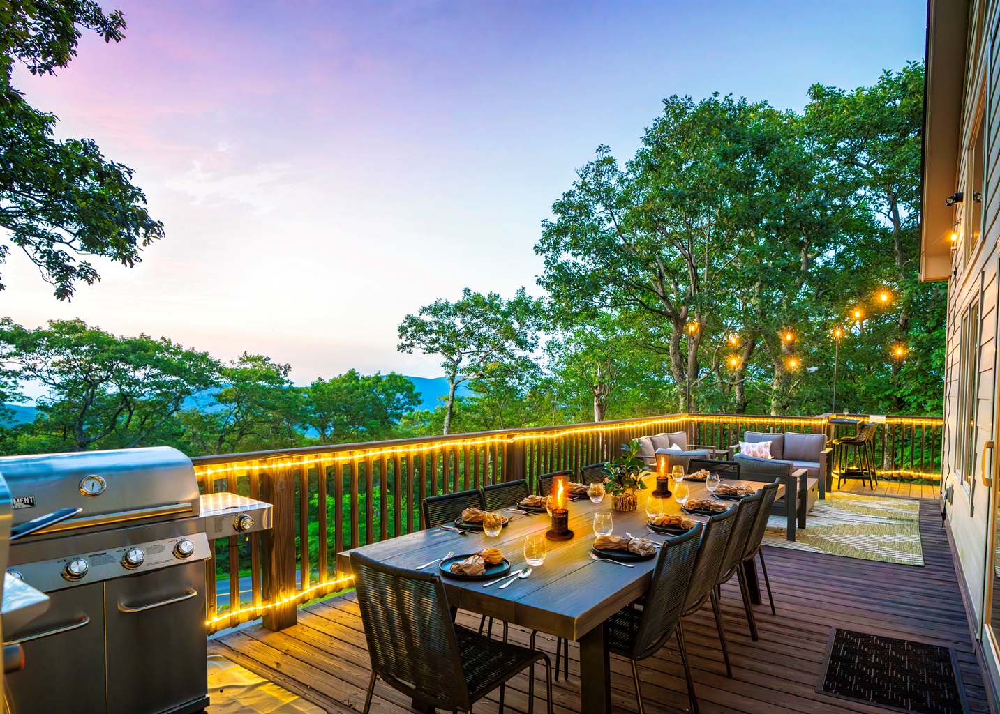 Twilight on the deck — mountains fading in the distance, wine glasses catching the glow of string lights, dinner sizzling on the grill. This is what gathering should feel like