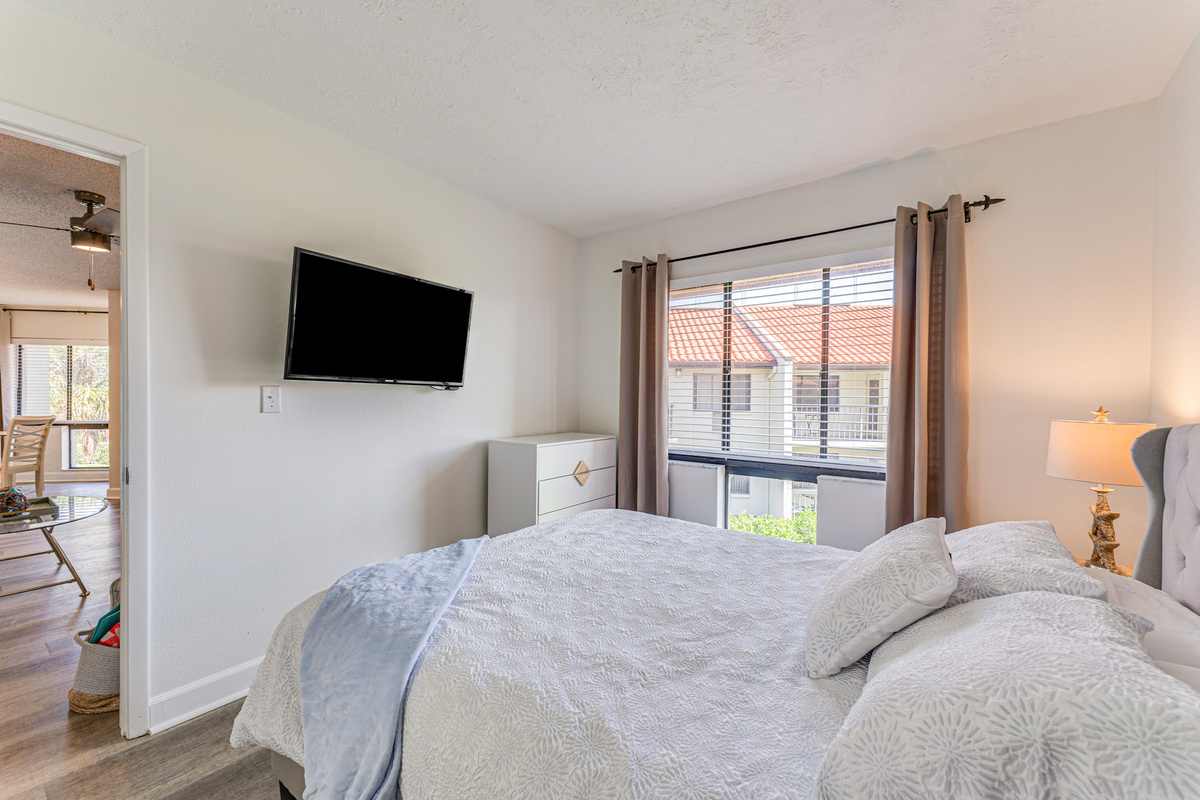 Relax in the comfort of the primary bedroom, featuring a private ensuite bathroom and direct access to the balcony. It's a peaceful retreat to recharge after a day in the sun.
