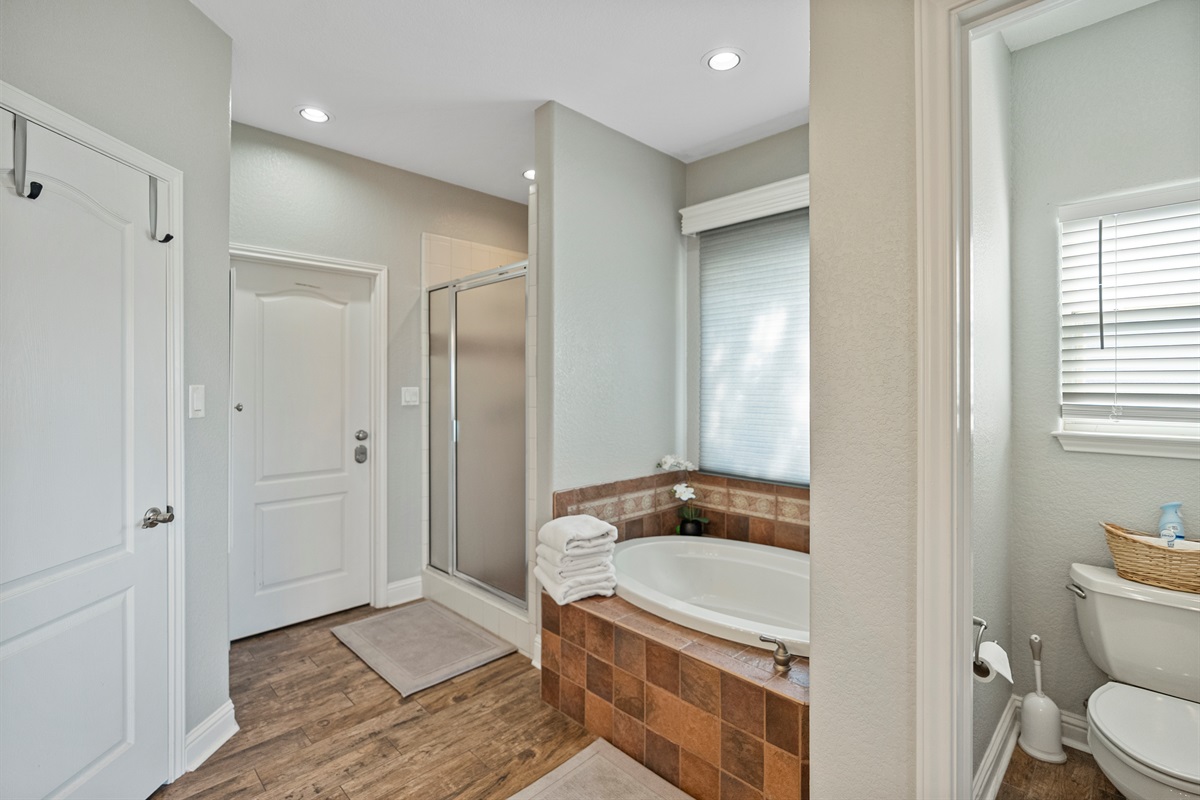 Features a garden tub, stand-up shower, private toilet room, and double vanity sinks.