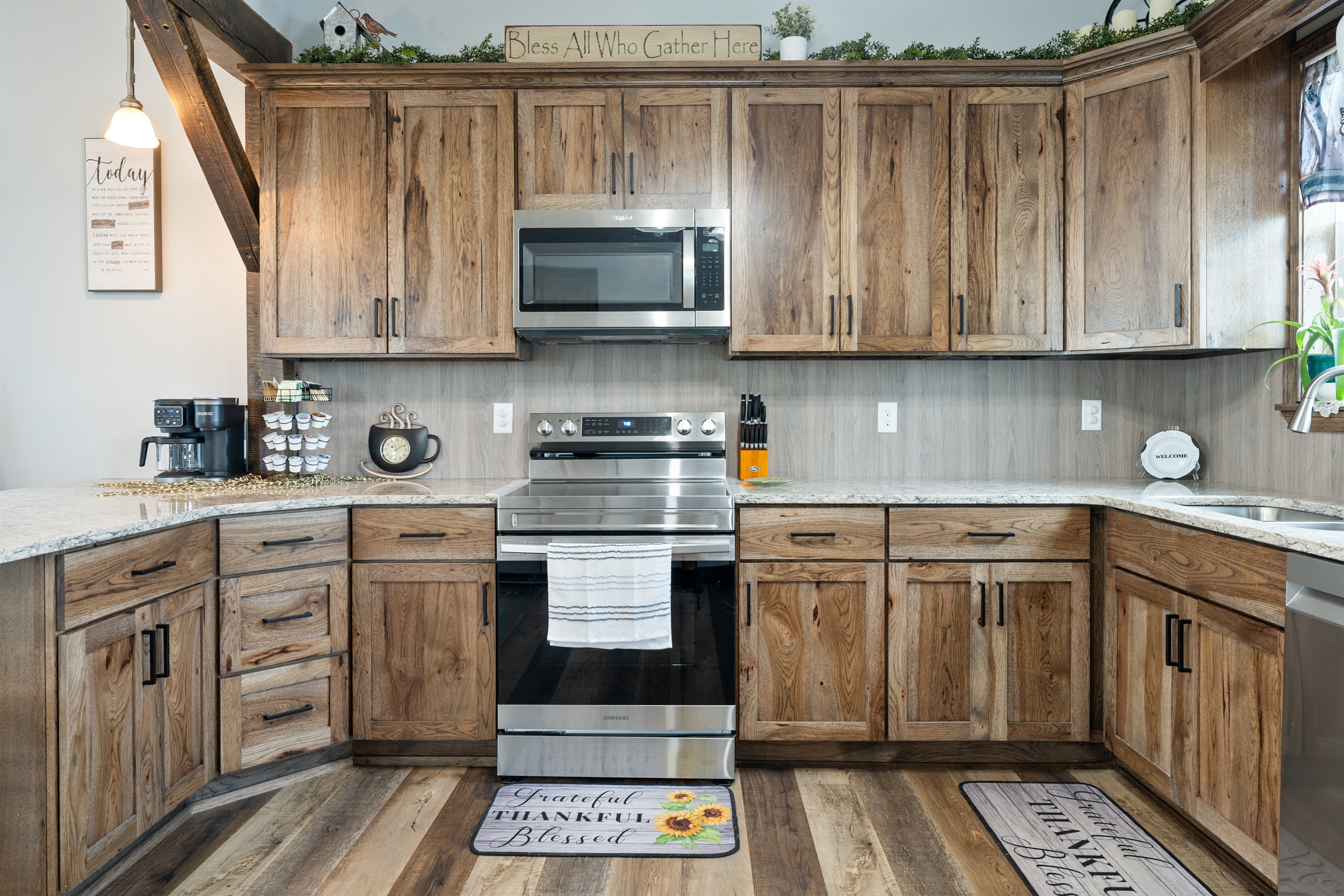 Beautiful farmhouse-style kitchen with warm wood cabinetry, granite counters, and a spacious island with bar seating for four.