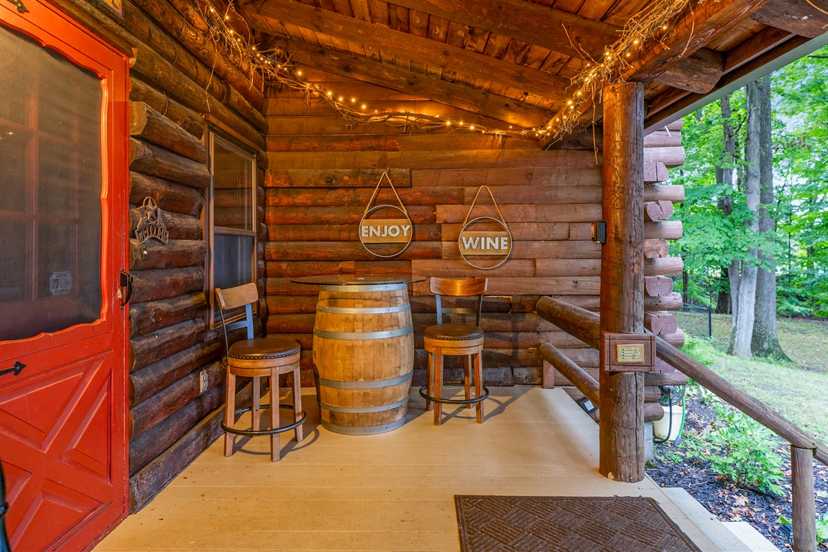 Cozy up on the rustic porch with twinkling string lights, a wine barrel table, and inviting seating—perfect for sipping Finger Lakes wine and enjoying peaceful evenings.