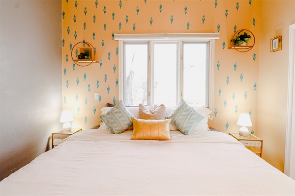 A cozy setting with yellow and gray walls, enhanced by the soft glow of a lamp and the modern touch of a TV, creating a welcoming and comfortable atmosphere.