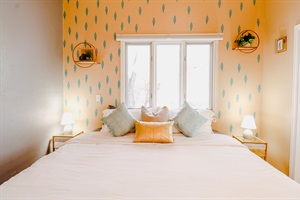 A cozy setting with yellow and gray walls, enhanced by the soft glow of a lamp and the modern touch of a TV, creating a welcoming and comfortable atmosphere.