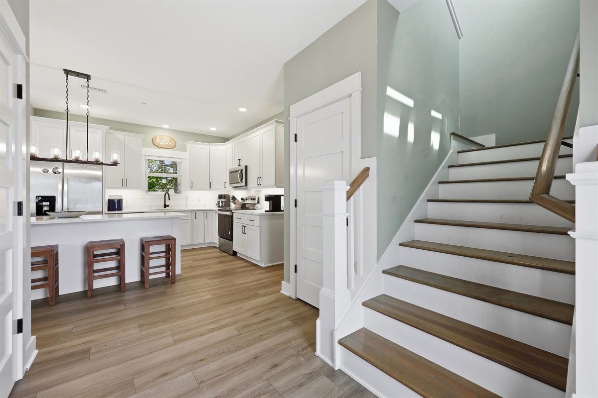 Open main level layout with spacious kitchen and staircase access upstairs