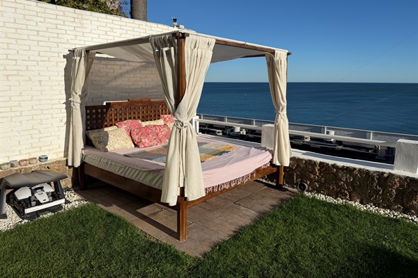 Private Balinese daybed with sea views, perfect for afternoon naps or evenings under the stars.