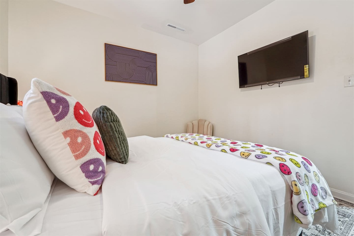A comfortable bedroom featuring a bed, a ceiling fan, a window, a TV, and a closet — a cozy space to rest and relax.
