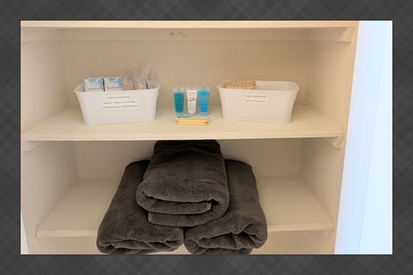 Well stocked linen closet includes extra toilet paper, towels, and essential toiletries. 
