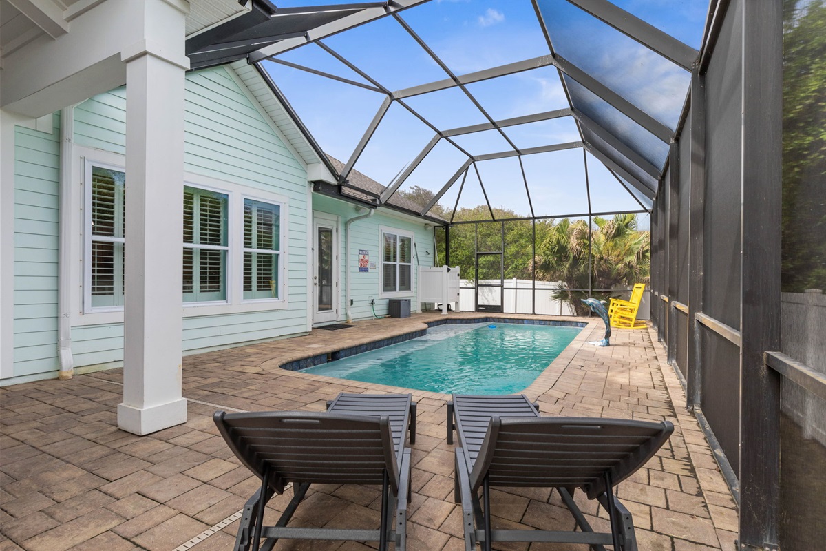 Spend the afternoon floating in your private screened pool, stretch out in the loungers between swims, and end the day in the yellow rockers as the light softens—an easy, sun-soaked retreat made for the kind of beach memories that linger.