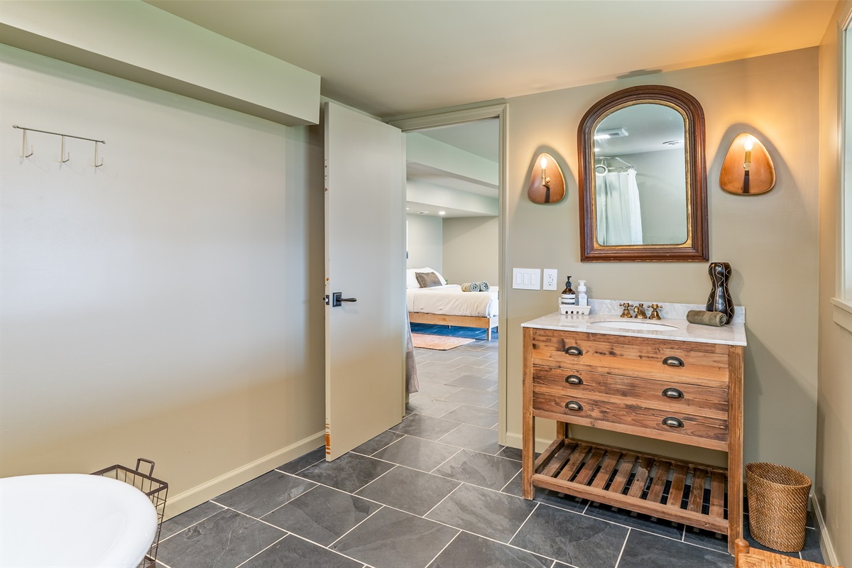 Rustic wood vanity meets modern elegance with warm lighting and thoughtful details in this inviting bath space in the lower level.