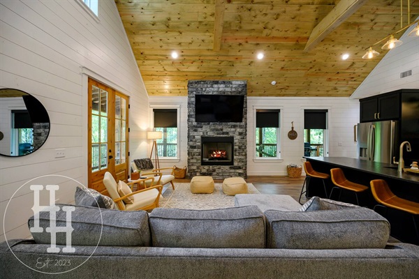 Living area with couch, designer chairs, gas fireplace, and smart TV.