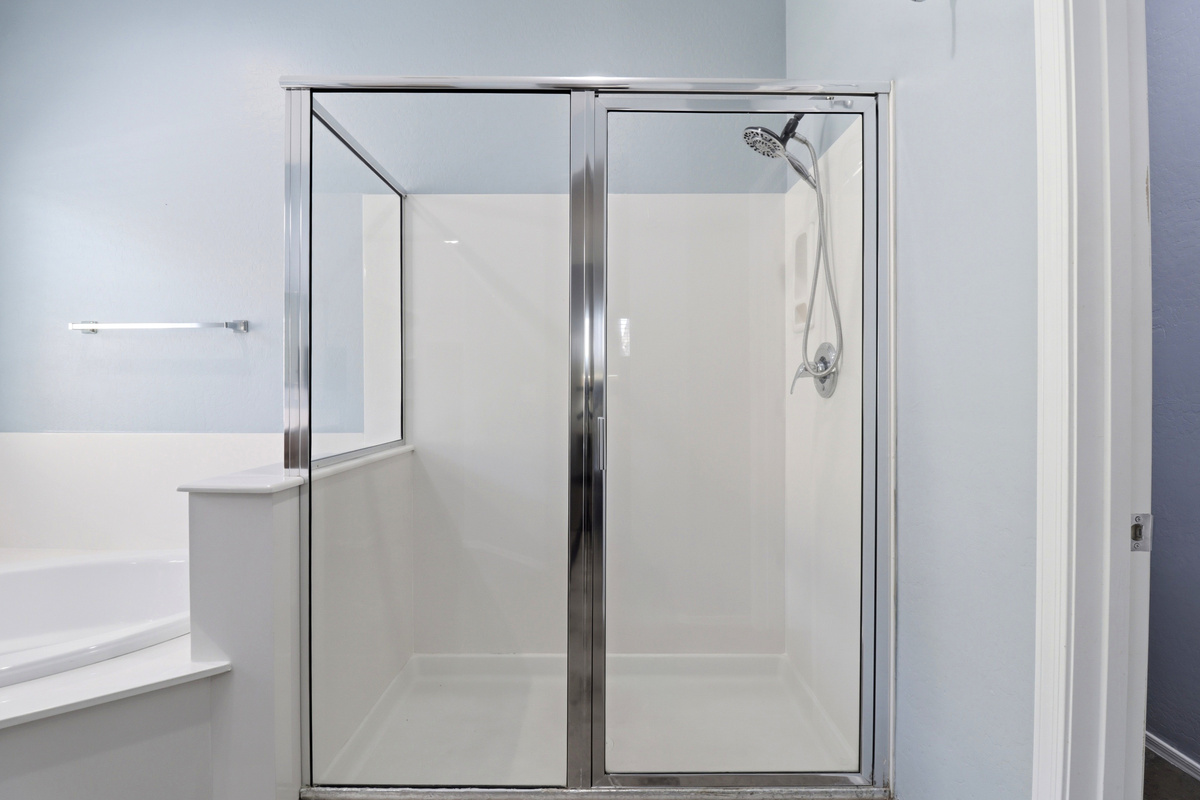 Walk-in shower with glass doors and a simple setup for daily use.
