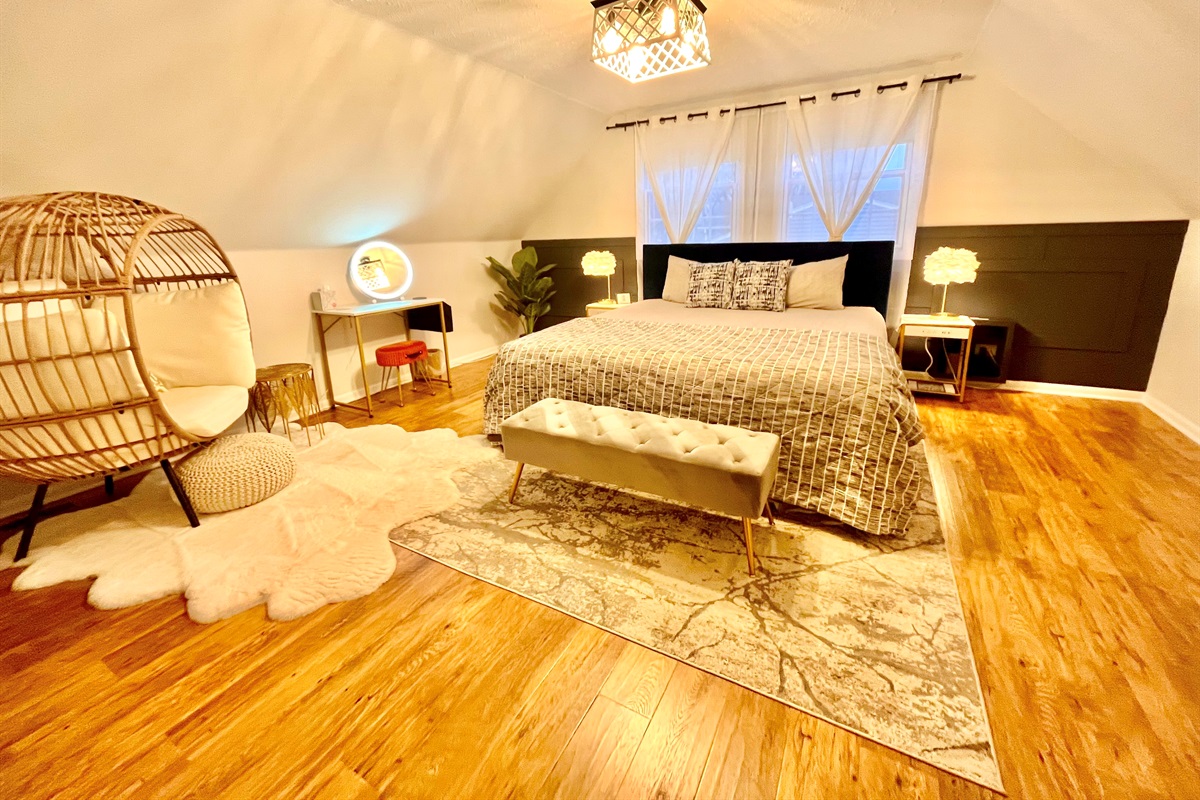 Beautiful upper master with king bed and egg chair make up table 