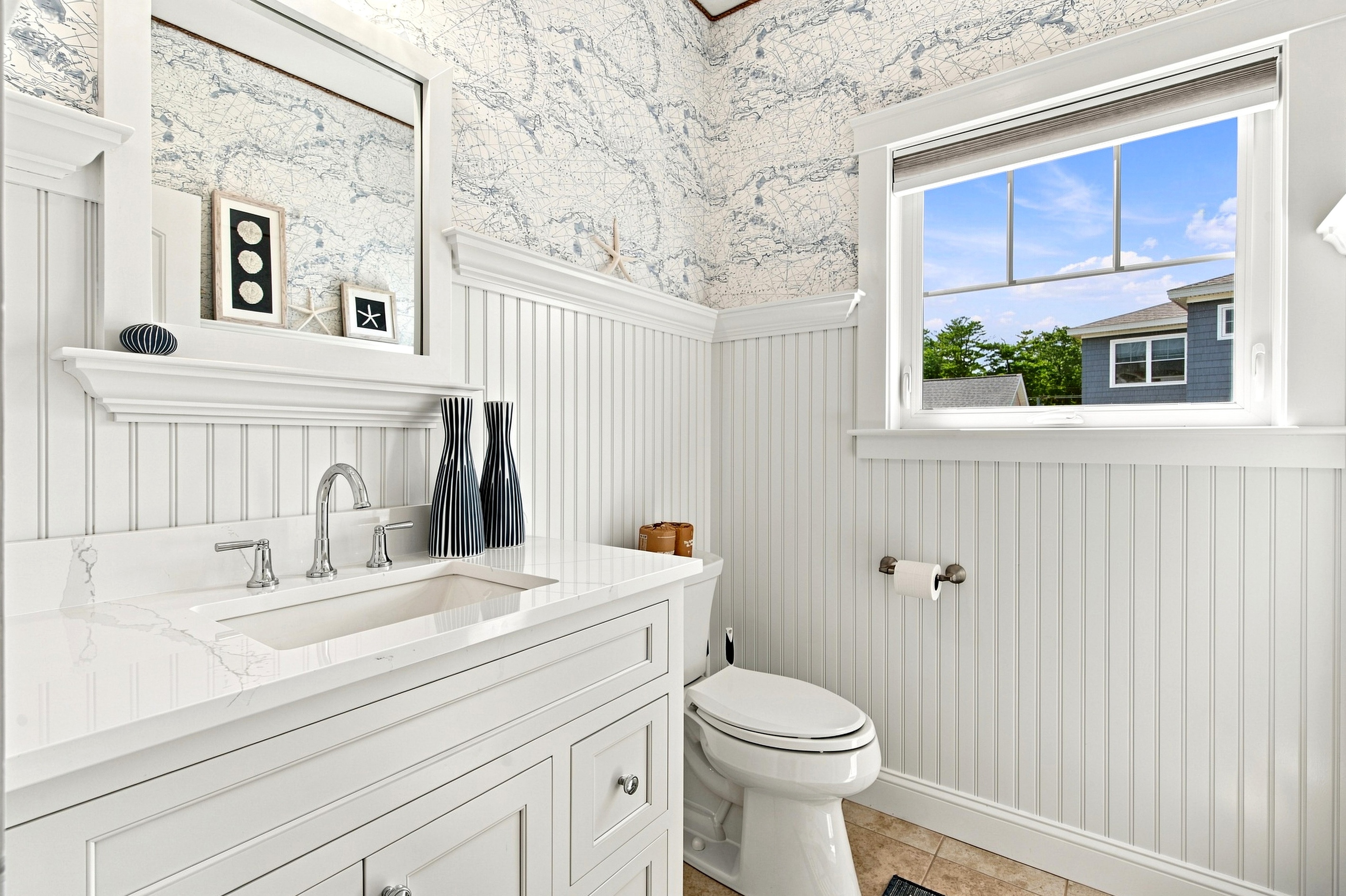 Bright coastal finishes and a clean, thoughtfully designed vanity create a refreshing bathroom retreat.