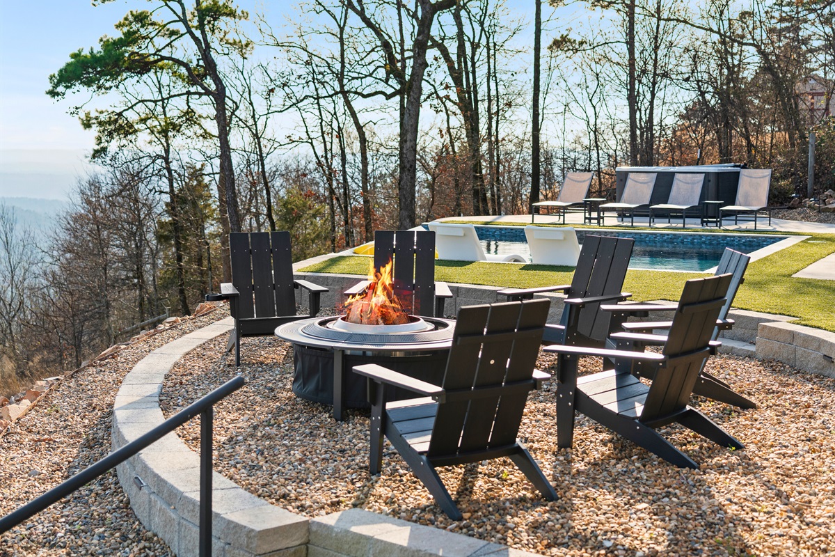 The fire pit area is ideal for cool evenings, with Adirondack chairs gathered around the flames and the pool just steps away.