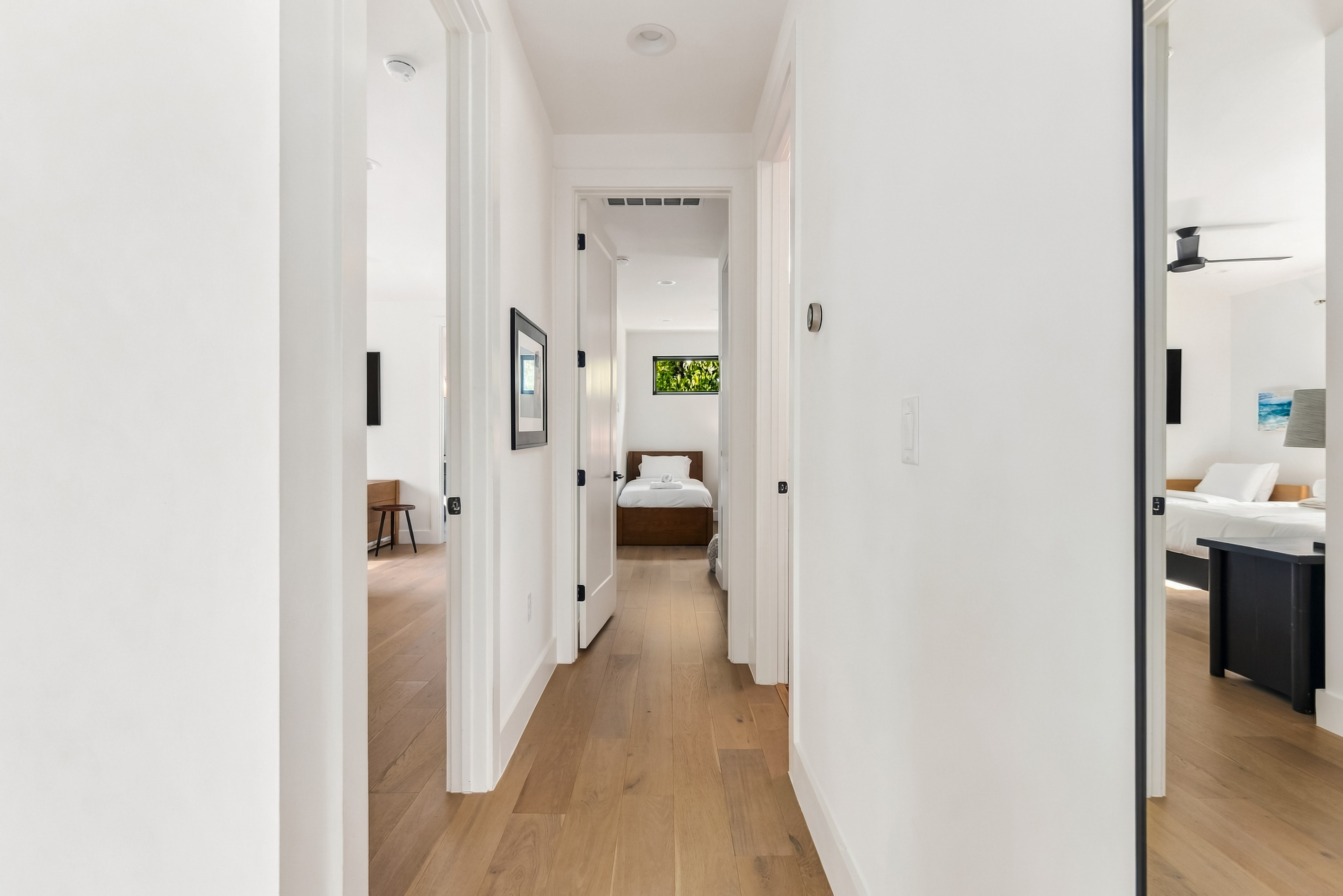 A sunlit hallway leads to the home's bedrooms and bathrooms.